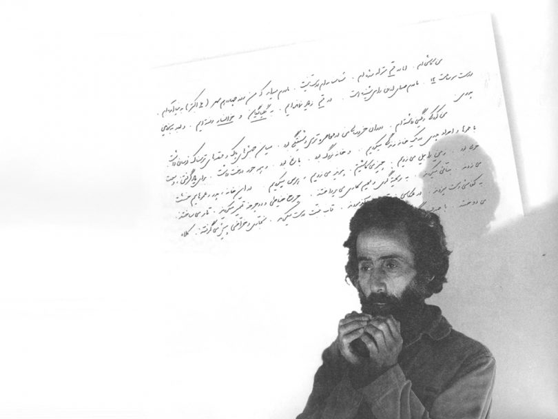 black and white image of handwriting on a piece of paper overlaid with the portrait of a somber man