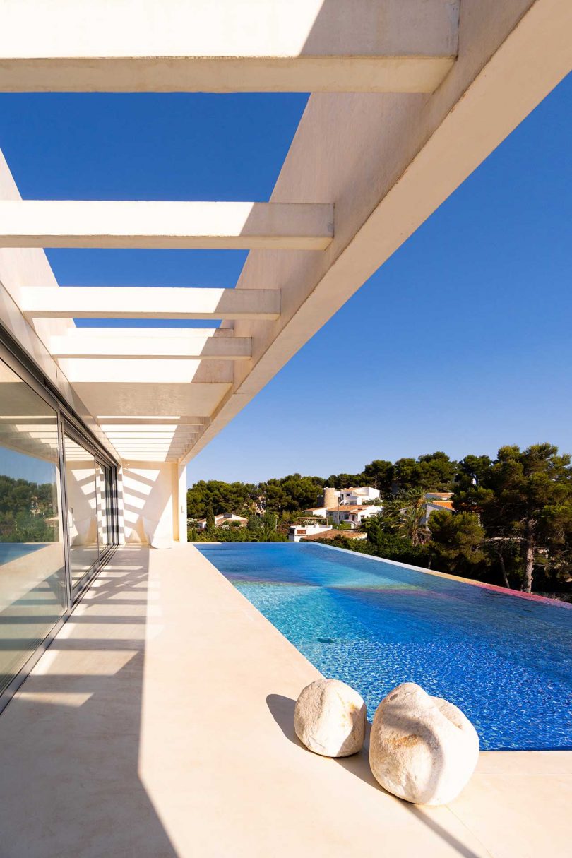 side view from patio looking to an elongated colorful swimming pool