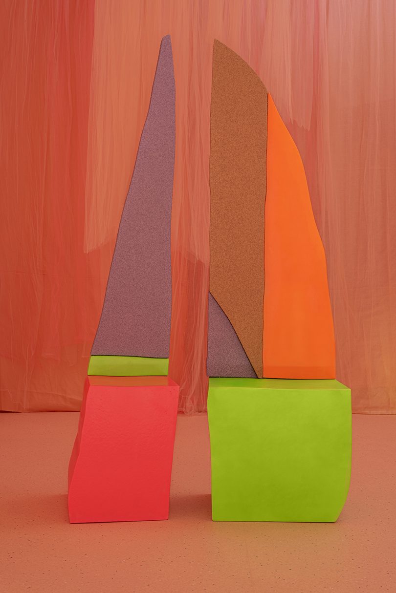 neon colored forms against a peach colored background