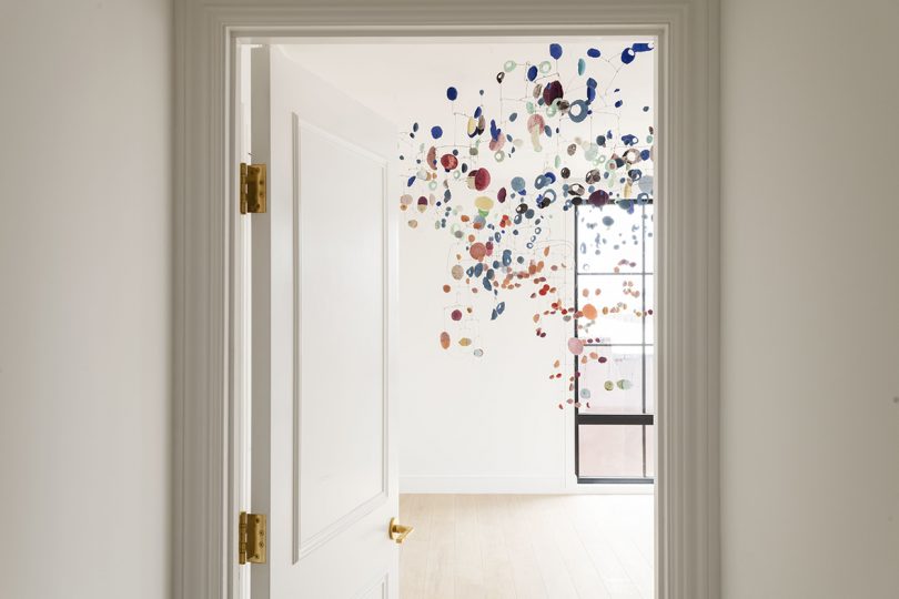 art installation of suspended colored disks in white room