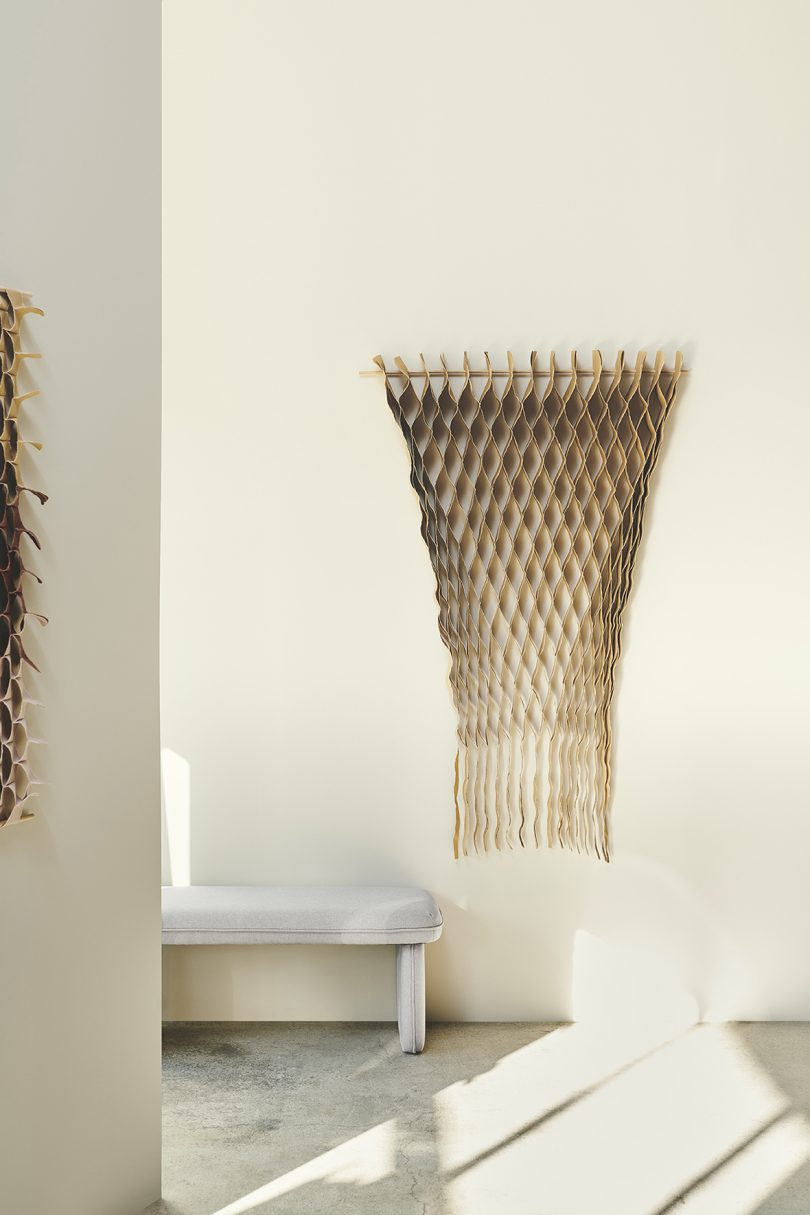 textile art hanging on white gallery walls