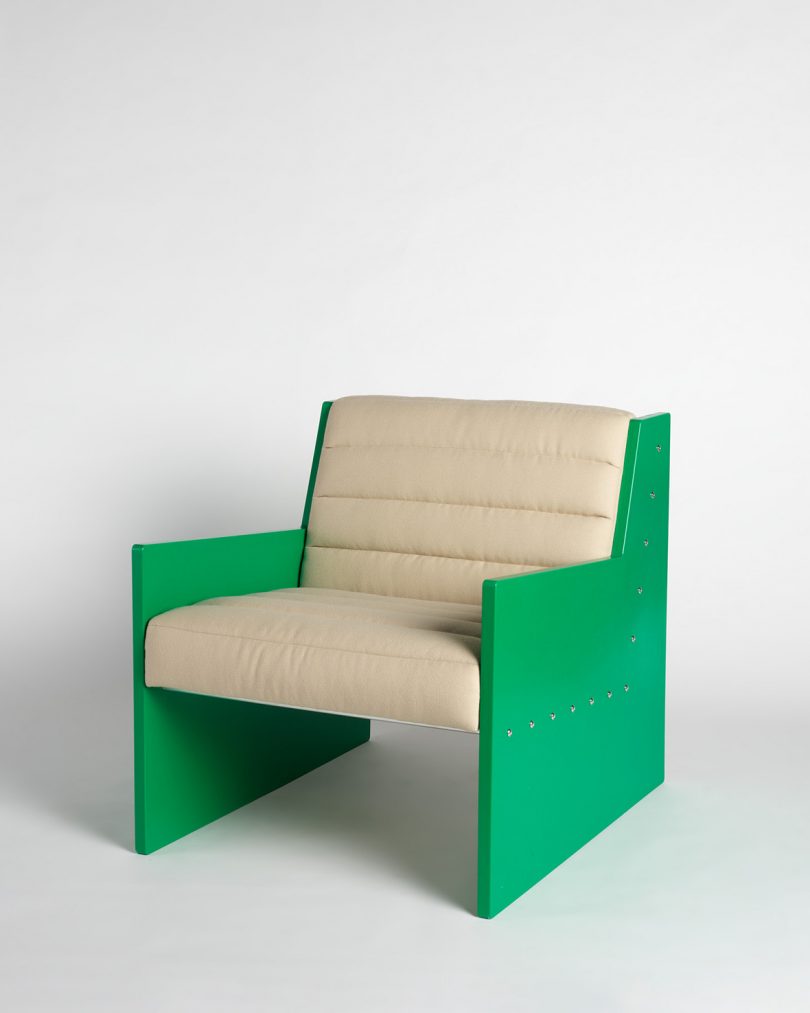 green and cream colored armchair on grey background