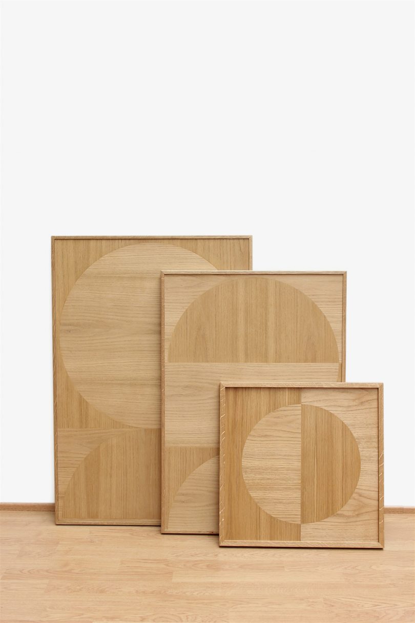 three pieces of wood marquetry art leaning against wall