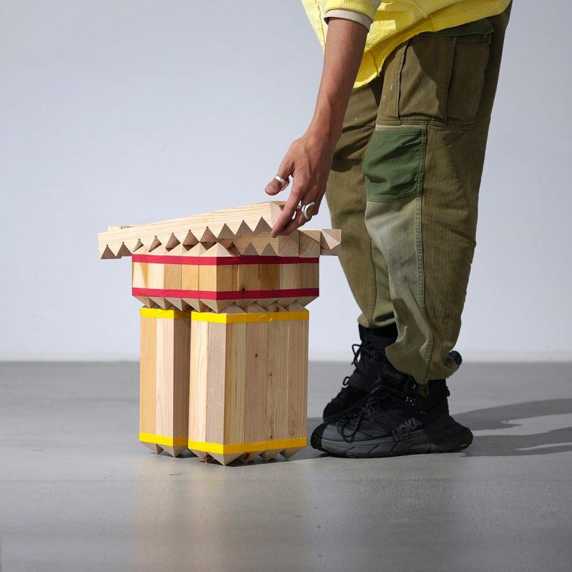 wooden structure made with blocks and masking tape with human for scale