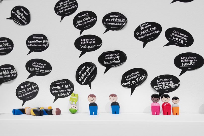 interactive exhibition with all white surfaces and small figurines representing people