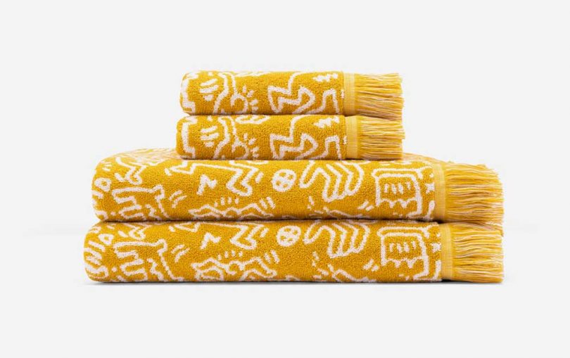 gold and white towels with keith haring artwork