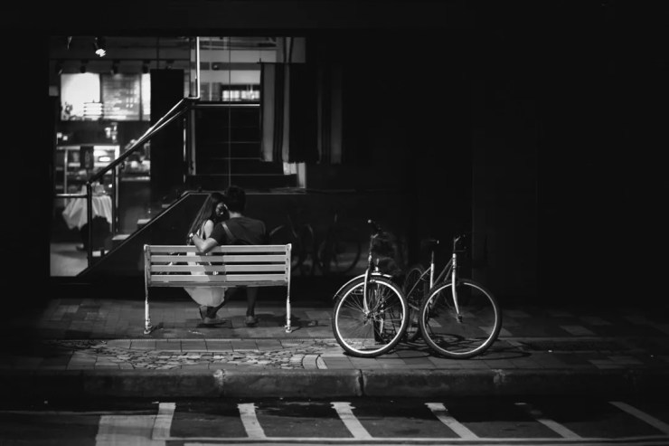 There is tension in this image on many levels. View the two bikes, the couple, the balance and positioning of both the bench and the bikes. The contrast of the right side of the frame compared to the left also creates tension. The positioning of the couple and their body language is more tension.