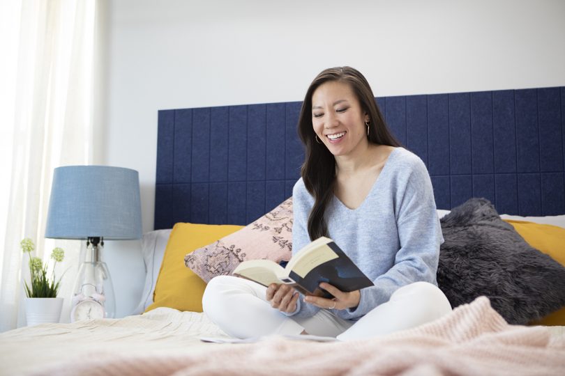 woman sitting in bed reading