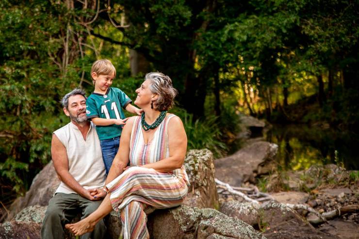 family sitting on rocks in rainforest