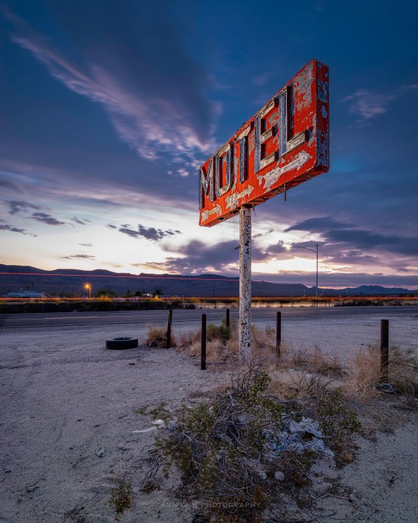 Once a large complex complete with a station and a motel with a swimming pool along Route 66, all that’s left today are the signs and a large empty parking lot. June 2021, Yucca, Arizona.