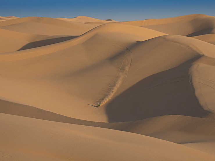 dirt bike racing across the sand dunes Imperial Dunes, CA