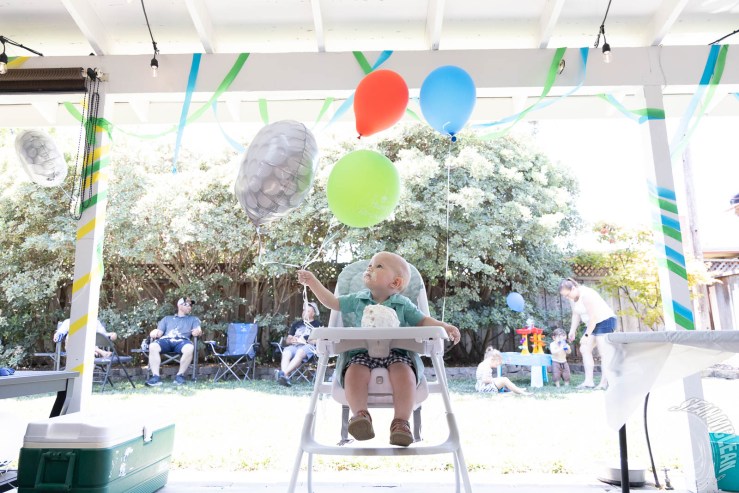 Baby boy, birthday cake, and balloons