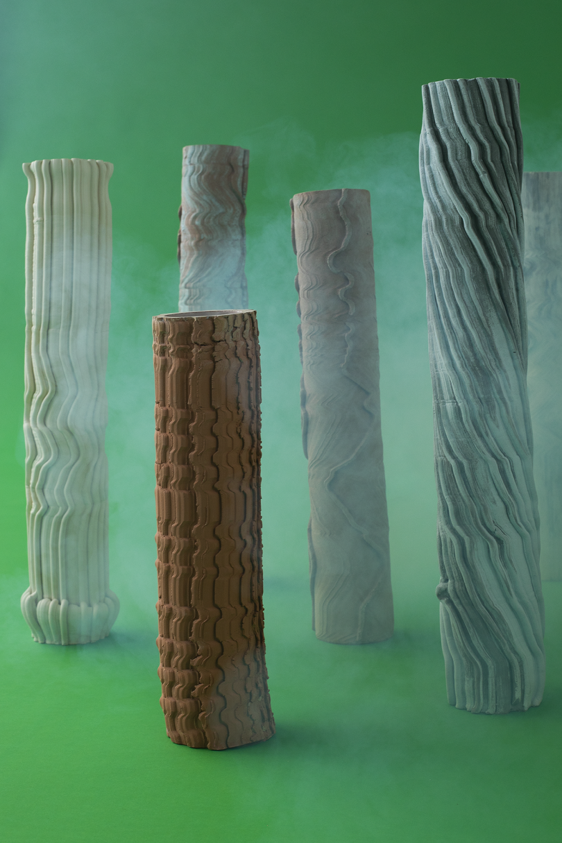 pillars of varying colors and heights on green background with white smoke