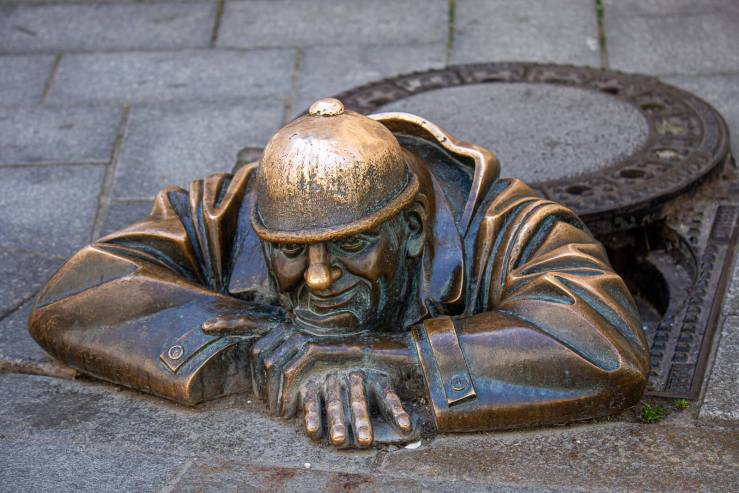 street art bronze sculpture soldier coming from manhole