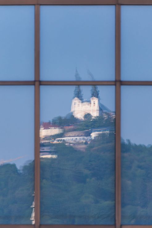 Pilgrimage church reflected in a building windows in Linz