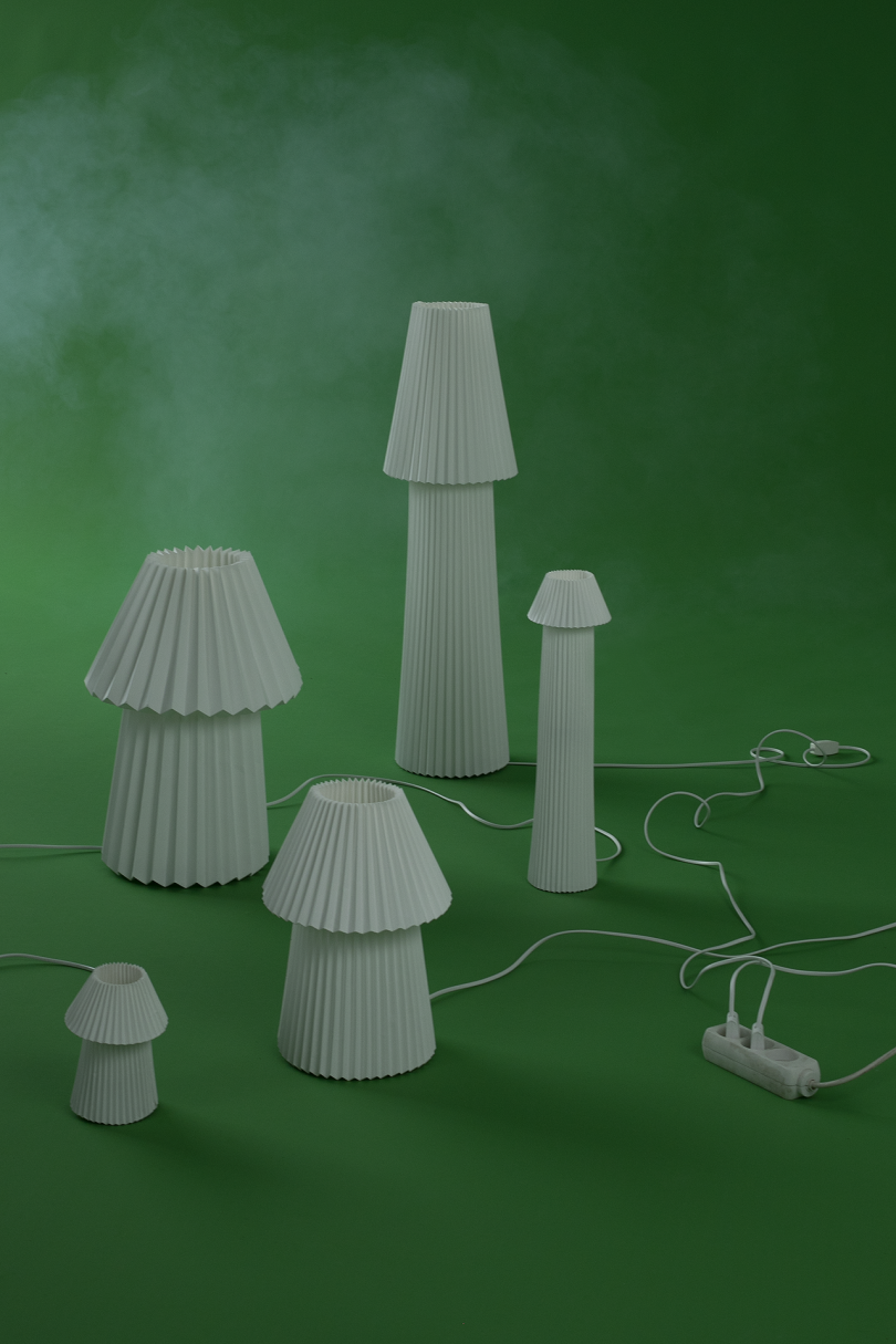 collection of white mushroom shaped lamps on green background with white smoke