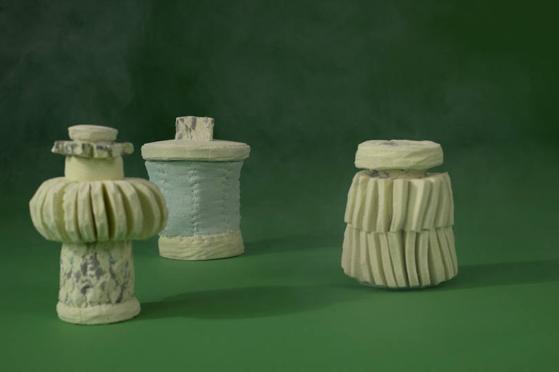 three light colored containers on dark green background